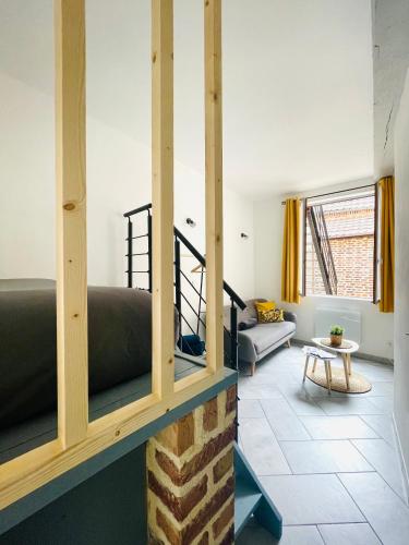 a living room with a bed and a couch at BE MY APPARTS, Studio de charme "LE CARILLON", DOUAI, Coeur de ville in Douai