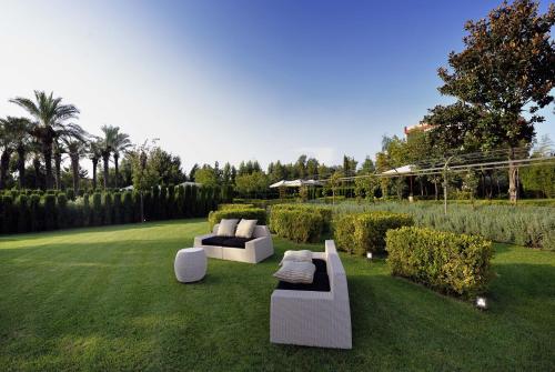 two white couches sitting on a grass field at Relais Villa Buonanno in Cercola