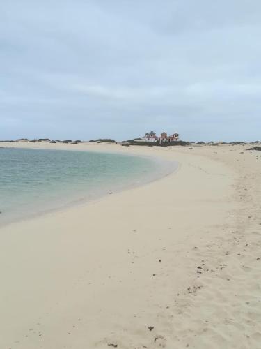 a beach with footprints in the sand and water at El Cotillo Tranquilidad,NearSea,Stylish,Well equipped in El Cotillo