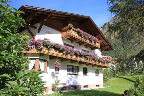 a building with flower boxes on the balcony at s'Huamatl in Sankt Leonhard im Pitztal