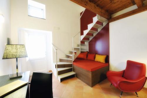 a living room with a staircase and a red chair at Relais Villa Buonanno in Cercola