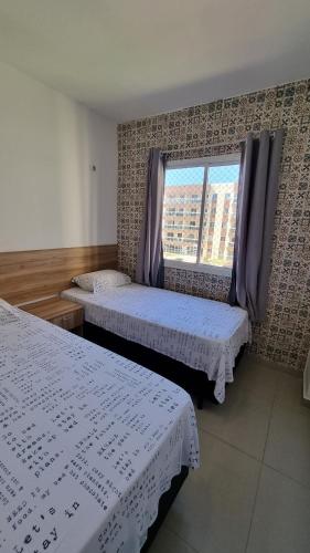 1 Schlafzimmer mit 2 Betten und einem Fenster in der Unterkunft VG FUN PRAIA ao lado do hotel Vila Galé, apto 1 in Fortaleza