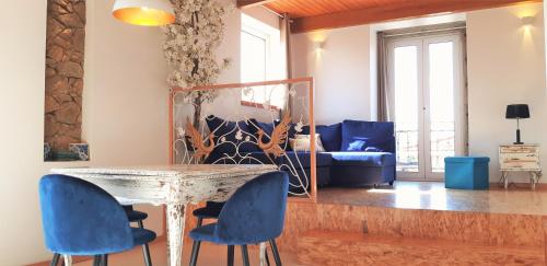 a living room with a table and blue chairs at Almar Apartments in Póvoa de Varzim