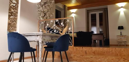 a table with two blue chairs and a mirror at Almar Apartments in Póvoa de Varzim