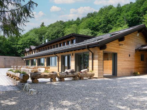a building with a bunch of logs in front of it at Relais Sauc & SPA - Agriturismo in Piancavallo