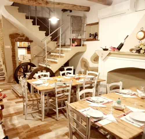 a dining room with wooden tables and chairs and a staircase at B&B Santu Giuvanni "Un tuffo nel passato Fonnese" in Fonni