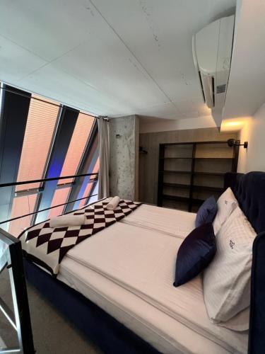 a large bed in a room with windows on a boat at NEON APARTMENTS in Sopot