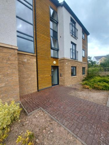 a building with a brick driveway in front of it at The Mews in Inverness