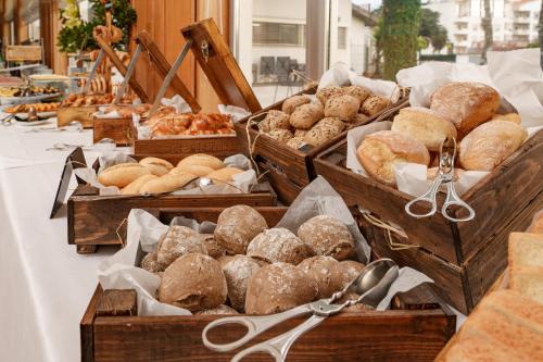 a table topped with wooden boxes filled with different types of bread at Hotel Dom Goncalo & Spa in Fátima