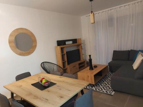 ein Wohnzimmer mit einem Holztisch und einem TV in der Unterkunft Valentinas apartment ! in Polis Chrysochous