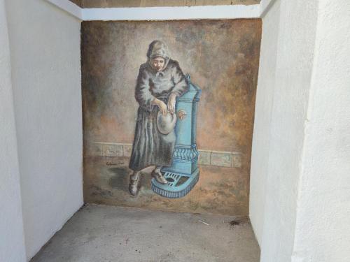 a painting of a woman sitting on a stove at Sa Dommu 'e su coro in Triei