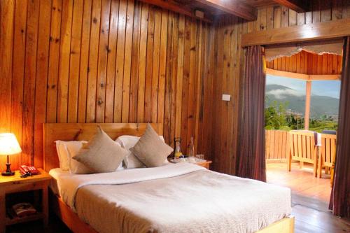1 dormitorio con 1 cama en una pared de madera en Rema Resort en Paro