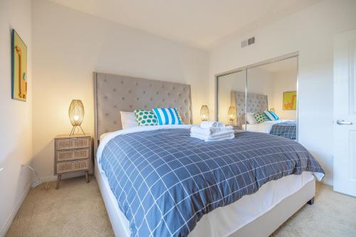 a bedroom with a blue and white bed and a mirror at Irvine 2Bedroom 2 Bathroom Apartment with Kitchen Pool gym in Irvine