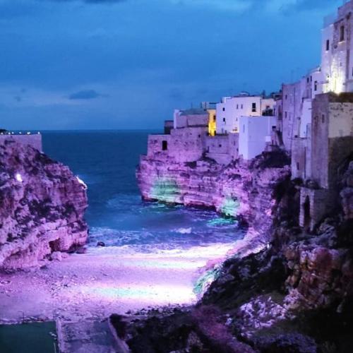una ciudad en un acantilado cerca del océano por la noche en LA CASA DI GIOVANNI, en Polignano a Mare