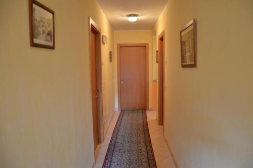 a hallway with a rug on the floor and a door at Locanda Milano 1873 in Brunate