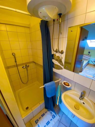 a bathroom with a shower and a sink and a tub at Sailor apartments in Pag