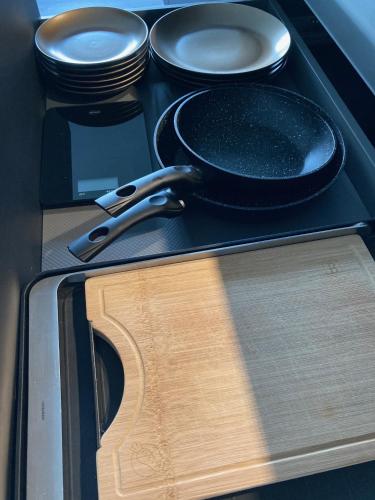 a stove with a frying pan and plates on it at Penthouse mit Dachterrasse, Meerblick, Gasgrill, Klimaanlage, Kamin, Luxus-Design-Apartment, 2 Minuten zum Strand in Binz