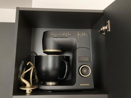 a coffeemaker with a coffee maker in a box at Penthouse mit Dachterrasse, Meerblick, Gasgrill, Klimaanlage, Kamin, Luxus-Design-Apartment, 2 Minuten zum Strand in Binz
