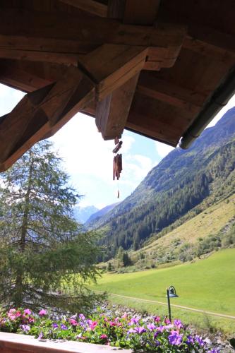 a view from the porch of a house with flowers at s'Huamatl in Sankt Leonhard im Pitztal