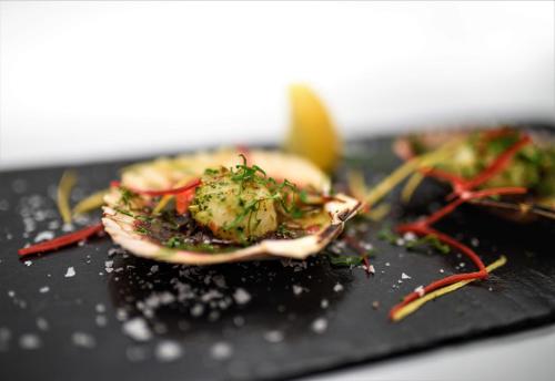 a piece of food on a black plate at No11 Boutique Hotel & Brasserie in Edinburgh