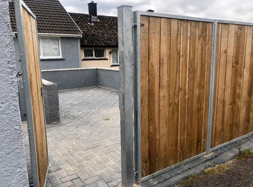 a wooden fence in front of a house at Welsh Getaway Home No 1 - 10 mins to Bike Park Wales in Merthyr Tydfil