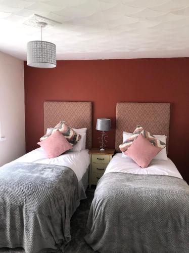 two beds sitting next to each other in a bedroom at Welsh Getaway Home No 1 - 10 mins to Bike Park Wales in Merthyr Tydfil