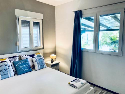 a bedroom with a bed with blue pillows and a window at Apartments Stara Baska in Stara Baška