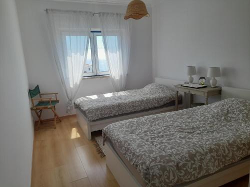 1 dormitorio con 2 camas y ventana en Villa Alegria, en Ericeira