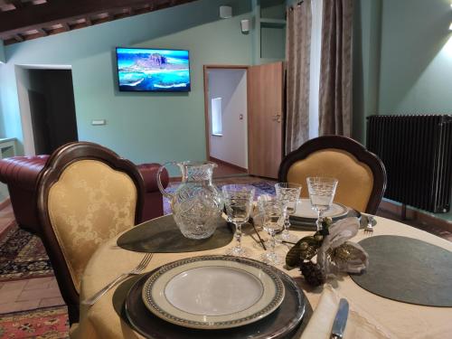 a dining room table with glasses and plates on it at Villa La Nussa in Capolona