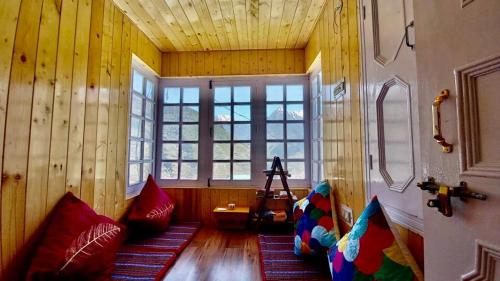 a room with wooden walls and pillows in a room at Lahaul Home Stay Sumnam in Tāndi