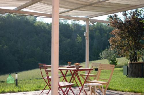 a wooden table and chairs under a pergola at La Silvana B&B in Coriano