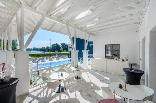 a patio with tables and chairs and a pool at Mercure Tokaj Center in Tokaj