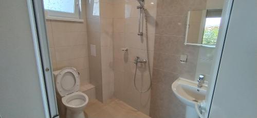 a bathroom with a shower and a toilet and a sink at Къща, стаи за гости Мери in Chernomorets