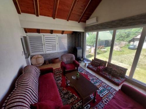 a living room with a couch and chairs and windows at House in beautiful nature in Pazarić