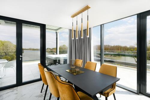 a dining room with a black table and yellow chairs at Mercure Tokaj Center in Tokaj