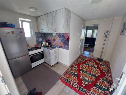 a small kitchen with a refrigerator and a rug at House in beautiful nature in Pazarić