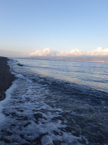 a beach with snow on the sand and water at Sicily House Soprano in Santo Stefano di Briga