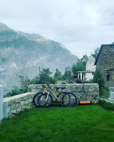 two bikes parked next to a stone wall at Lahaul Home Stay Sumnam in Tāndi