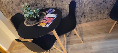 a black chair with a table and a plant on it at A ESTRENAR PRECIOSOS APARTAMENTOS APARTHOTEL INTER2, NEW APARTMENTS lN APARTHOTEL 12 months open! self check in! RESERVA Garaje! in Salou