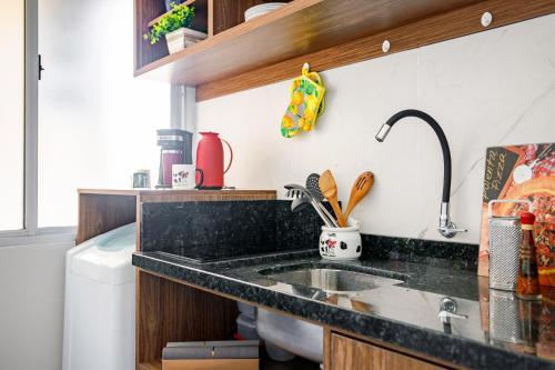 a kitchen with a sink and a counter top at Comodidade no Coração de Floripa in Florianópolis