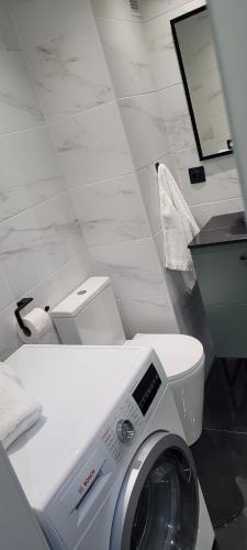 a bathroom with a washing machine and a toilet at A ESTRENAR PRECIOSOS APARTAMENTOS APARTHOTEL INTER2, NEW APARTMENTS lN APARTHOTEL 12 months open! self check in! RESERVA Garaje! in Salou