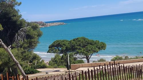 a view of the beach from a fence at A ESTRENAR PRECIOSOS APARTAMENTOS APARTHOTEL INTER2, NEW APARTMENTS lN APARTHOTEL 12 months open! self check in! RESERVA Garaje! in Salou