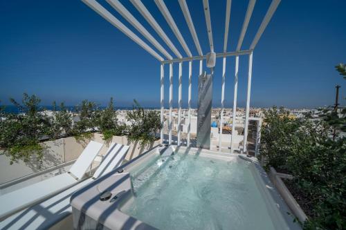 a hot tub on a balcony with a view of the beach at Dimora Valmar Luxury Charm in Polignano a Mare