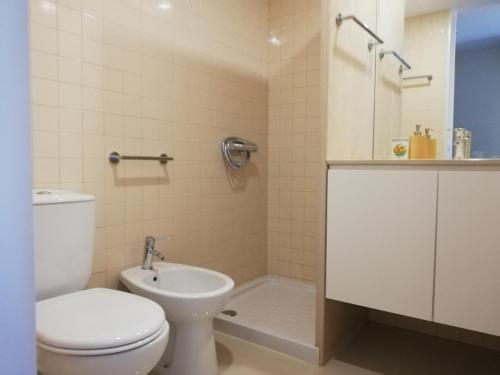 uma casa de banho com um WC, um lavatório e uma banheira em Station House em Guimarães