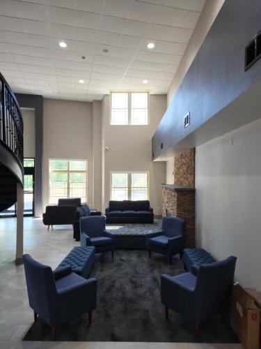 a waiting room with couches and chairs and a fireplace at La Quinta Inn & Suites by Wyndham Lake George in Lake George