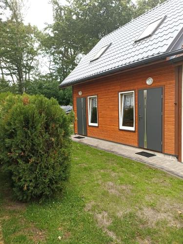 uma pequena casa de madeira com uma porta verde em Domki z widokiem na morze u Jasia em Trzęsacz