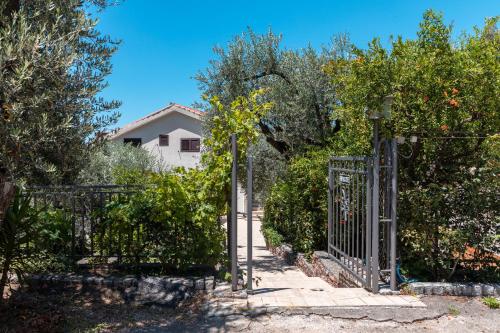 - Entrada a un jardín con puerta de hierro en Olive Garden Apartments, en Sveti Stefan