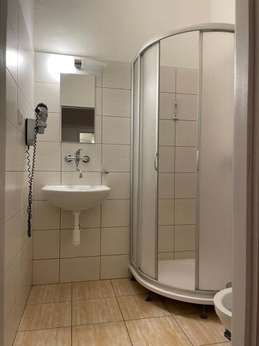 y baño con ducha y lavamanos. en Gallery Hotel SIS en Praga