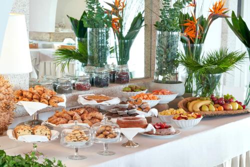 ein Buffet mit vielen verschiedenen Speisen auf einem Tisch in der Unterkunft Due Lune Puntaldia Resort & Golf in San Teodoro