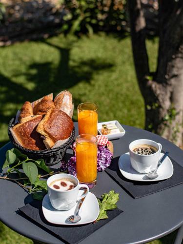 einen Tisch mit einem Korb Brot und Tassen Kaffee in der Unterkunft Le Clos des Eucalyptus in Plan-de-la-Tour